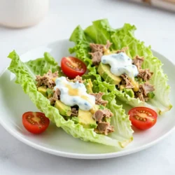 To make delicious avocado tuna salad, you need these key items: - 1 can (5 oz) tuna, drained - 1 ripe avocado, mashed - 1/4 cup Greek yogurt (or mayo for a richer taste) - 1 tablespoon Dijon mustard - 1 tablespoon lemon juice - 1 celery stalk, finely chopped - 1/4 red onion, finely chopped - 1 tablespoon fresh dill, chopped (or 1 teaspoon dried dill) - Salt and pepper to taste - 8 large lettuce leaves (like Romaine or Butter lettuce) - Cherry tomatoes, halved (for garnish) These ingredients work together to create a creamy and fresh dish. The tuna provides protein, while the avocado adds healthy fats and creaminess. If you want to boost the flavor of your avocado tuna salad, consider these add-ins: - Chopped pickles or relish - Sliced olives - Chopped bell peppers - A dash of hot sauce - Chopped nuts for crunch These options can add a new layer of taste and texture. Try mixing them in to find your favorite combo. You can easily swap some ingredients for others. Here are a few ideas: - Use canned salmon instead of tuna for a different flavor. - Swap Greek yogurt for sour cream for a tangy taste. - If you don't have dill, try parsley or cilantro. - For a lower-carb option, use cucumber slices instead of lettuce leaves. These substitutions let you customize the dish to your liking while keeping it tasty and fresh. {{ingredient_image_1}} To make avocado tuna salad lettuce wraps, start by gathering your ingredients. In a mixing bowl, add one can of drained tuna and one ripe, mashed avocado. Mix these two until they blend well. Next, add 1/4 cup of Greek yogurt or mayo, 1 tablespoon of Dijon mustard, and 1 tablespoon of lemon juice. Stir everything together until the mixture is smooth. Now, fold in the finely chopped celery and red onion. Add 1 tablespoon of fresh dill or 1 teaspoon of dried dill. Season with salt and pepper to taste. Adjust flavors as needed by adding more salt or lemon juice. When mashing the avocado, ensure it is ripe. A ripe avocado is soft and easy to mash. Use a fork to mash the avocado until it is creamy. This helps blend better with the tuna. When mixing, be gentle to keep some texture. Over-mixing can make the salad mushy, which is not what you want. For serving, take one large lettuce leaf, like Romaine or Butter lettuce. Spoon a generous amount of the tuna salad mixture into the center of the leaf. Top it off with halved cherry tomatoes for a pop of color and taste. Fold the lettuce leaf around the filling to form a wrap. You can serve them right away, or chill them for later. Enjoy your fresh and tasty lettuce wraps! Choosing ripe avocados is key. Look for avocados that feel slightly soft when you press them. If they are too hard, they need more time to ripen. For tuna, select a can labeled as “light” or “solid white” for best taste. Check the expiration date on the can. Freshness matters! To get great flavor, mash the avocado well. You want it creamy but not too smooth. Mix it with the tuna until just combined. Stir in Greek yogurt or mayo slowly. This keeps the texture nice and adds creaminess. Don't skip the lemon juice; it brightens the dish. Adjust salt and pepper to your taste. Remember, taste as you go! For fresh and crisp lettuce wraps, wash the leaves gently. Pat them dry with a towel. Thick leaves like Romaine hold the filling well. Lay the leaves flat before adding the tuna salad. This helps to keep your wrap from tearing. Serve the wraps right away for the best crunch! Pro Tips Use Fresh Ingredients: Fresh herbs and vegetables enhance the flavor of your tuna salad. Opt for freshly chopped dill and crisp celery for the best taste. Adjust Consistency: If you prefer a creamier texture, feel free to add more Greek yogurt or mayo to the mixture until it reaches your desired consistency. Experiment with Flavors: Don’t hesitate to add other ingredients like diced bell peppers, capers, or a dash of hot sauce for a unique twist on your salad. Chill Before Serving: For the best flavor, chill the tuna salad in the refrigerator for 30 minutes before serving. This allows the flavors to meld beautifully. {{image_2}} You can switch out tuna for chicken or chickpeas. If you use chicken, I recommend cooked and shredded chicken. This gives a nice texture. For a vegetarian twist, use chickpeas. Smash them slightly and mix as you would with tuna. Both options keep the dish fresh and tasty. If you like heat, try adding some hot sauce or diced jalapeños. A sprinkle of cayenne pepper adds a kick without overpowering. You can also mix in a bit of smoked paprika for a warm flavor. Adjust the spice to suit your taste and enjoy the new twist! To make this dish vegan, replace the tuna with mashed chickpeas or tofu. Use plant-based yogurt instead of Greek yogurt. You can also skip the yogurt altogether and add more avocado. This keeps it creamy and rich while being completely dairy-free. Enjoy your healthy, vegan version! To keep your leftover tuna salad fresh, place it in an airtight container. This will help keep moisture in and air out. You should eat it within 2-3 days for the best taste. If you notice any changes in color or smell, it’s best to throw it away. Store your lettuce in the fridge to keep it crisp. Wrap the leaves in a damp paper towel and place them in a plastic bag. This helps keep them fresh for about a week. Avoid washing the leaves until you are ready to use them. Excess moisture can cause them to spoil faster. Use glass or plastic containers with tight lids for the best storage. They help prevent air and moisture from getting in. For tuna salad, a medium-sized container works best. For lettuce, a larger container will keep the leaves flat and unbroken. Make sure to label your containers with the date for easy tracking. Yes, you can make Avocado Tuna Salad ahead of time. I often prepare it a few hours before serving. It tastes great when chilled. Just store it in an airtight container in the fridge. This keeps it fresh and flavorful. Avoid adding the lettuce until you’re ready to eat. This way, the lettuce stays crisp and doesn't get soggy. Avocado Tuna Salad is packed with health benefits. It combines protein from tuna and healthy fats from avocado. Here are some key benefits: - Heart Health: Tuna is rich in omega-3 fatty acids. These fats can help lower bad cholesterol. - Nutrient-Dense: Avocados are high in vitamins E, C, and K. They also provide fiber. - Low-Carb Option: Using lettuce wraps instead of bread cuts carbs. It is a great choice for those watching their carbs. - Hydrating: This salad includes fresh vegetables, which add hydration. The Avocado Tuna Salad lasts about 2 days in the fridge. Be sure to store it in an airtight container. After 2 days, the avocado may brown and lose its taste. If you notice any changes in smell or texture, it’s best to discard it. Always check for freshness before eating leftovers. In this blog post, we explored how to make a tasty avocado tuna salad. We covered key ingredients, cooking steps, and tips for fresh lettuce. You can also swap or add ingredients to suit your taste. Choose your protein, spice it up, or go vegan. Remember to store leftovers correctly to keep them fresh. This dish offers great flavor and health benefits. Enjoy making and serving it your way. You’ll love this quick meal for any day!
